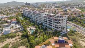 Un hôtel à plusieurs étages doté de balcons, d’une piscine et offrant une vue sur le paysage urbain environnant.