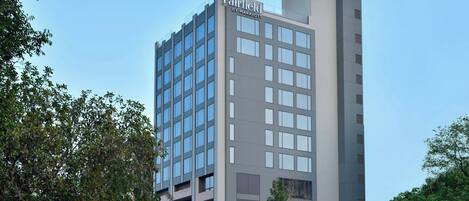 A modern hotel building with a sign reading "Fairfield by Marriott" on the top.