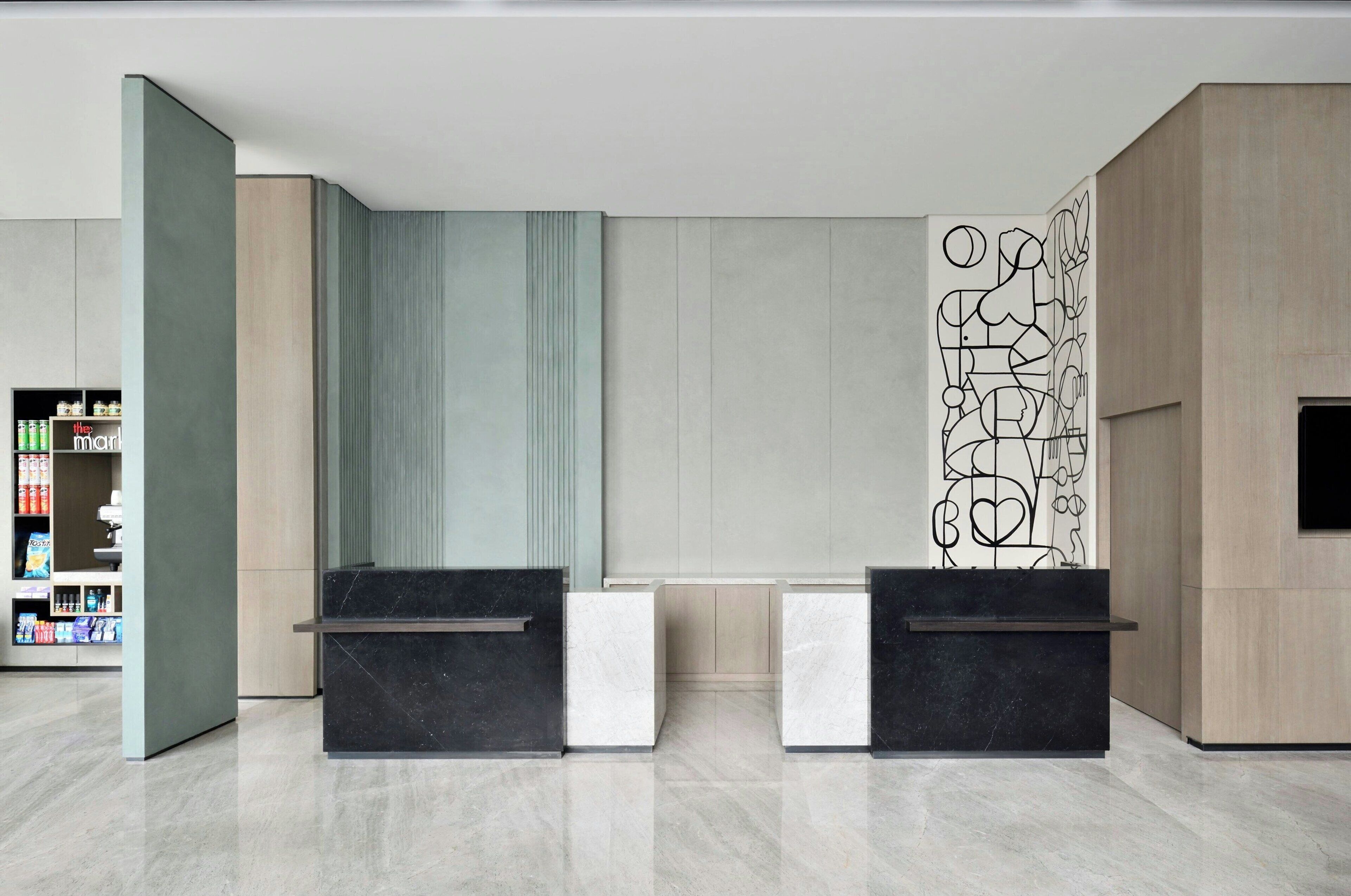 A reception area with a modern design, featuring a marble floor, a reception desk, and a wall with abstract art.