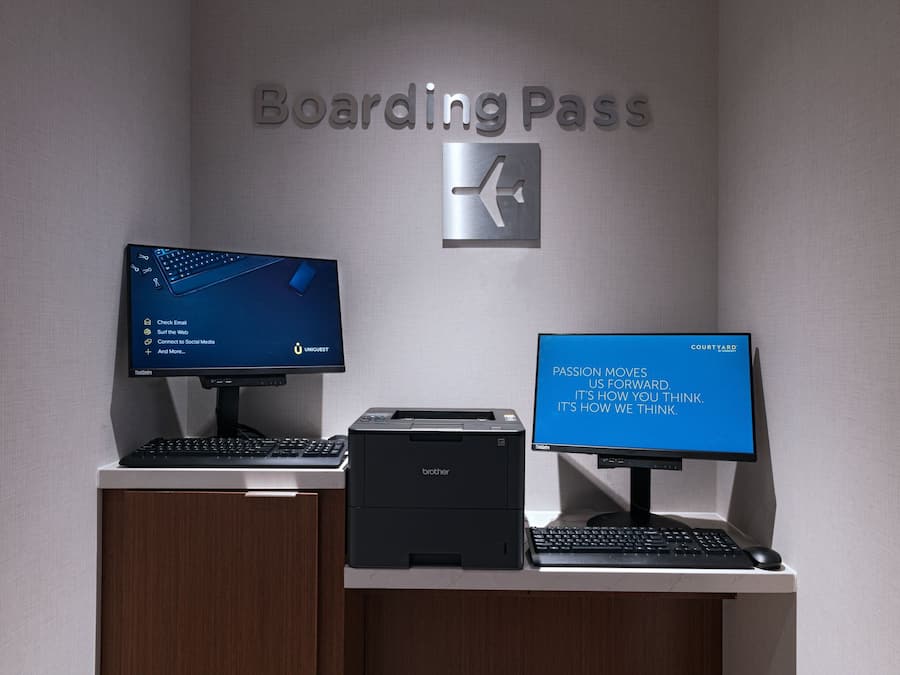 Un bureau avec deux écrans, une imprimante et un clavier.
