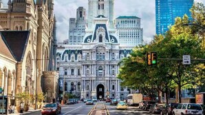 A historic building with a prominent clock tower, surrounded by modern skyscrapers and a busy street. - Luxe City Hall Suite by Rittenhouse Square (Philadelphia)