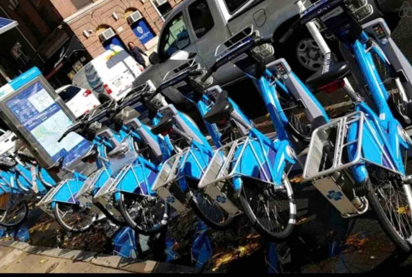 Una fila de bicicletas azules estacionadas en un entorno urbano.