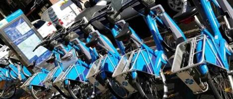 Una fila de bicicletas azules estacionadas en un entorno urbano.
