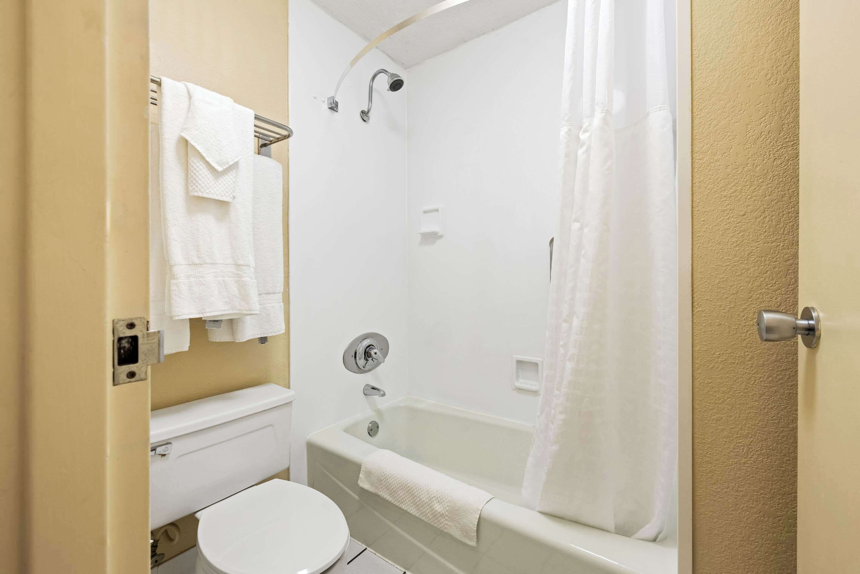 A bathroom with a toilet, a bathtub, and a shower.