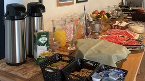 Un bufé de desayuno con diversas opciones de comida, bebidas y cafeteras.