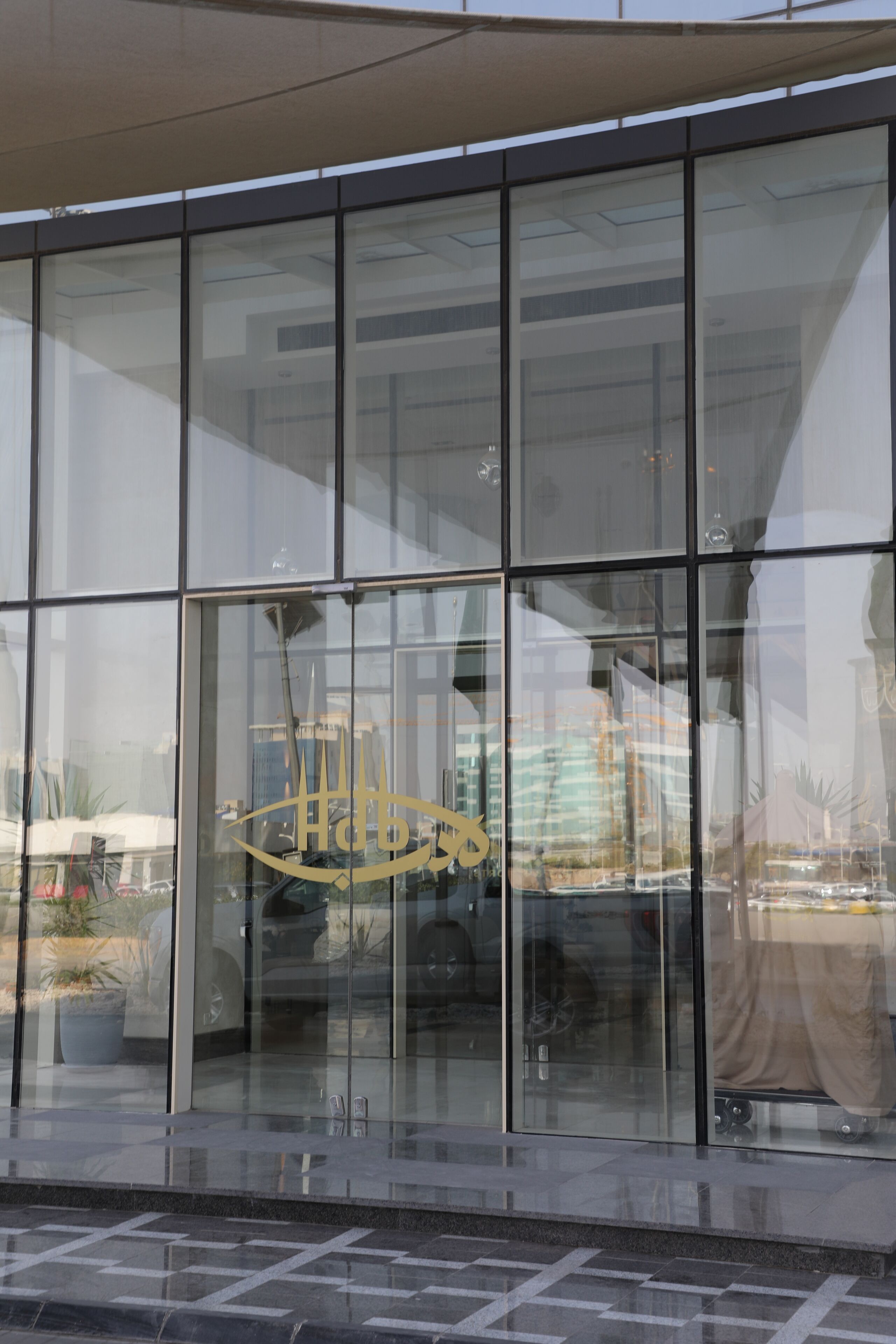 Un bâtiment moderne doté de grandes fenêtres en verre et d’un logo bien visible.