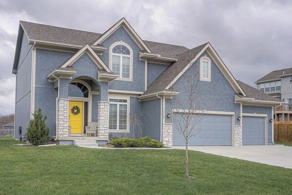 Stunning two-story home with a welcoming entrance, beautifully set amidst a well-manicured lawn.