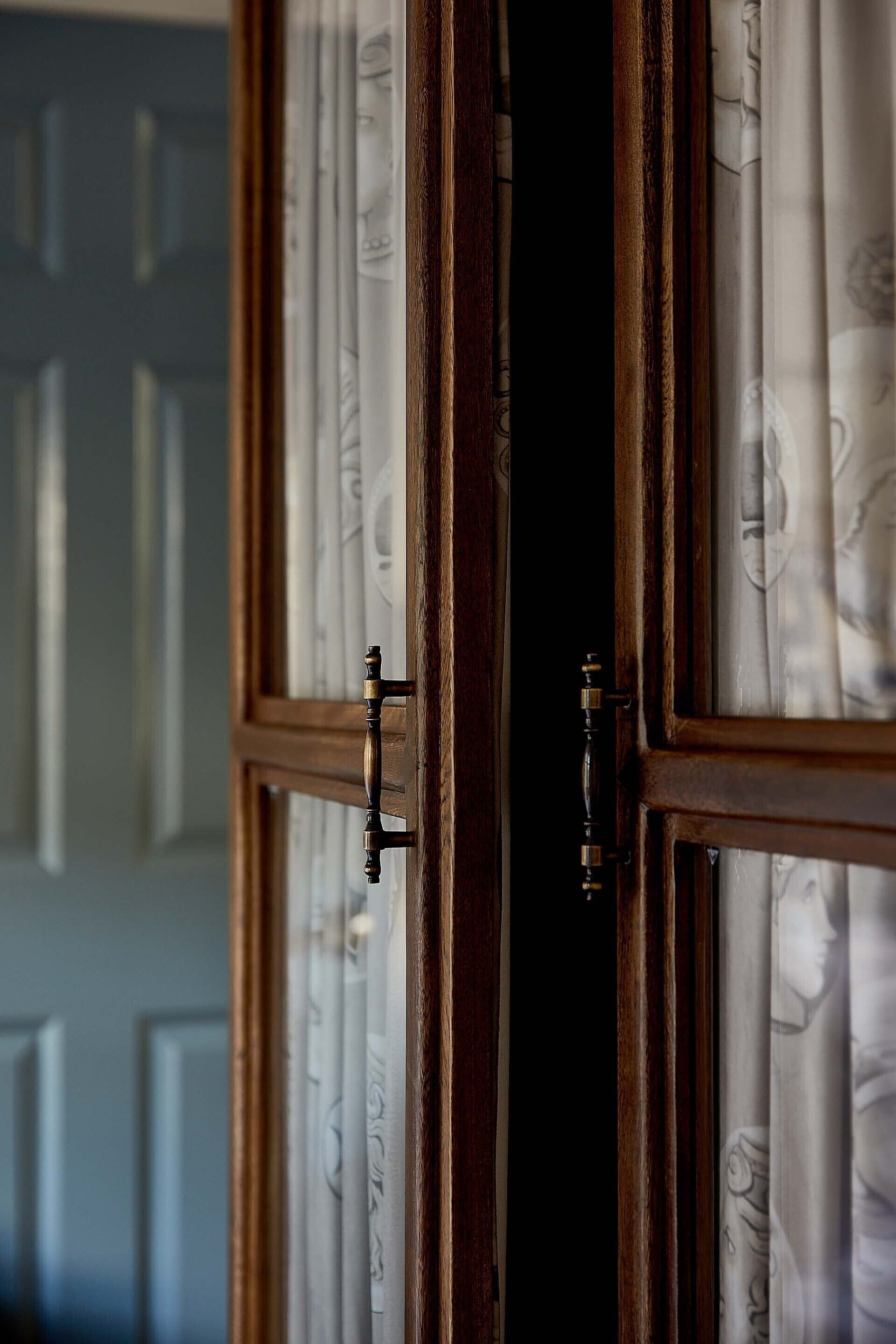 A wooden door with a brass handle and glass panels.