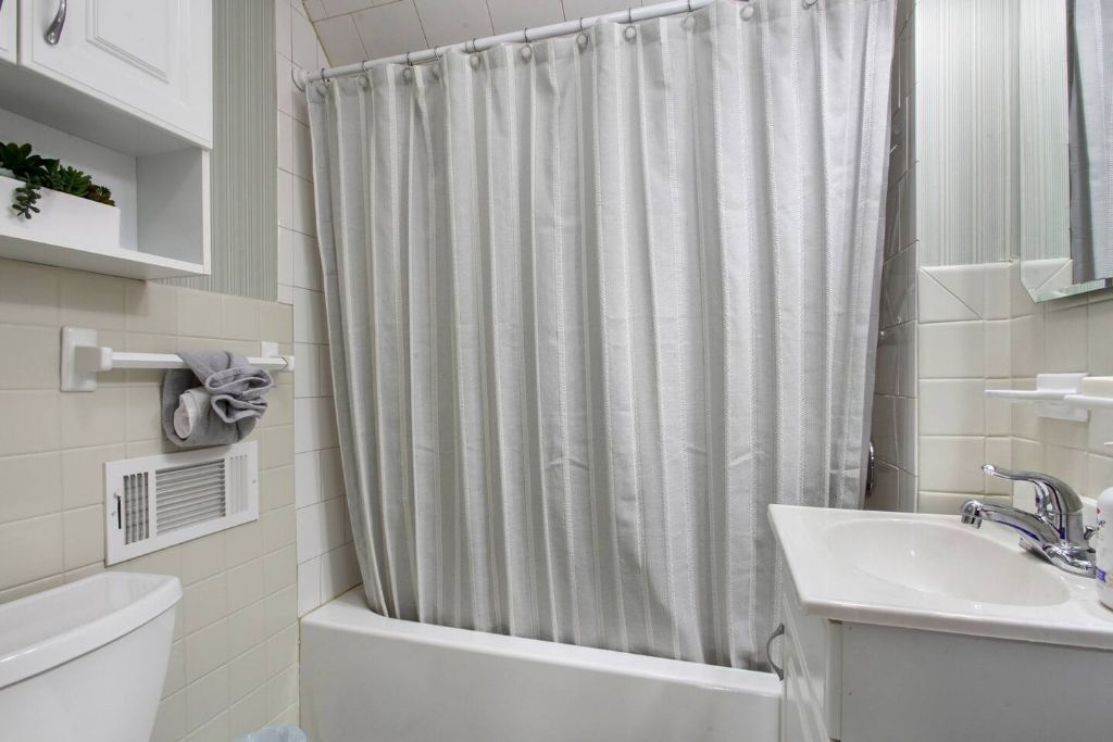 Ein Badezimmer mit Badewanne, Waschbecken und Duschvorhang.