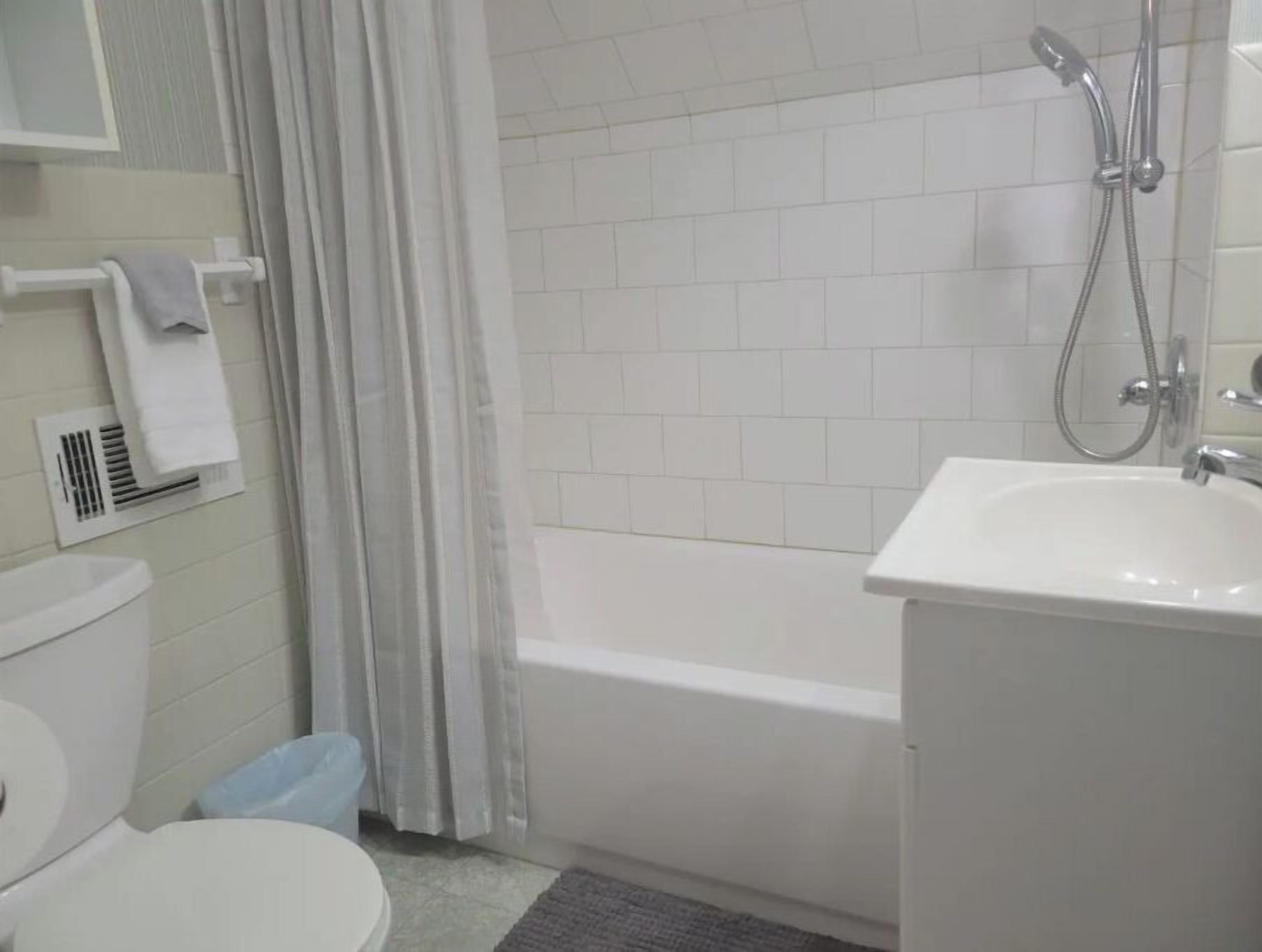 Ein Badezimmer mit Toilette, Waschbecken, Dusche und Handtuchhalter.