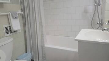Ein Badezimmer mit Toilette, Waschbecken, Dusche und Handtuchhalter.