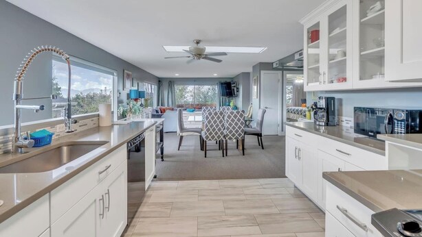 Una cocina moderna con una isla central, electrodomésticos integrados y mucho espacio de almacenamiento.