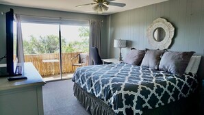 A bedroom with a large bed, a desk with a computer, a chair, a lamp, and a view of the outdoors. - “Stunning Views! ” Luxury 4 Bedroom, 2 Bathroom Vacation Duplex in Downtown Salt Lake Capitol Hill (Salt Lake City)