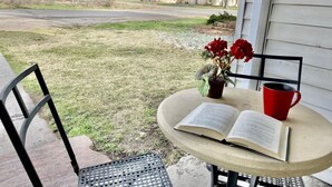 A patio with a table, a chair, a book, a red mug, and a flower vase. - Heritage House -Great Location, Skiing, Walk to Restaurants, Sports Fields, Train.  Large rooms (Heber City)