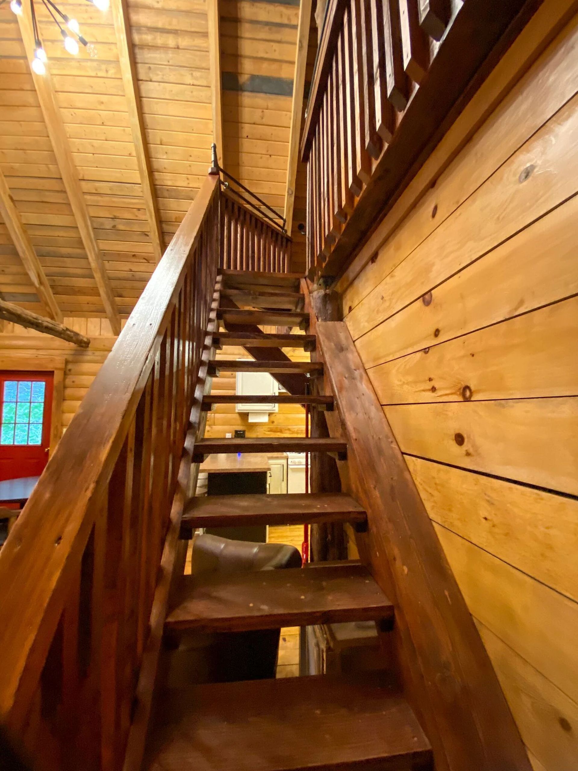 A wooden staircase with a railing, leading to a lower level.