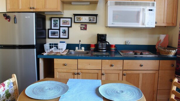 A kitchen with wooden cabinets, a stainless steel refrigerator, a microwave, a sink, and a coffee maker. - for animal lovers - cute, little Bunkhouse attached to the horse barn (Sonoita)
