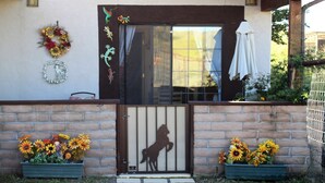 A house with a brown door, a horse silhouette, and two flower planters with sunflowers. - for animal lovers - cute, little Bunkhouse attached to the horse barn (Sonoita)