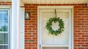 A brick house with a white door and a wreath hanging on it. - Nona's Cottage-Waynesboro/Shenandoah Valley, VA (Waynesboro)