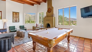 A spacious room with a pool table, green chairs, and a fireplace. - Upscale Home: Amazing Views! Pool & Hot Tub (Tucson)