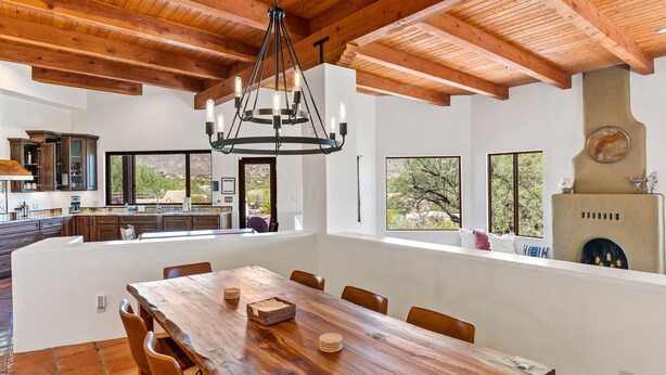 A spacious kitchen with a large island, wooden ceiling beams, and a modern chandelier. - Upscale Home: Amazing Views! Pool & Hot Tub (Tucson)