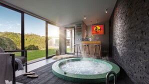Un moderno espacio de spa con un jacuzzi, un bar y un amplio ventanal con vistas al exterior.