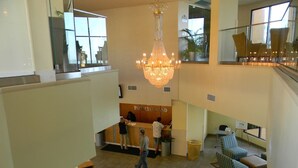 A hotel lobby with a reception desk, a chandelier, and seating areas. - Paradise @ Oceanfront Suite/Dogs OK! (Myrtle Beach)