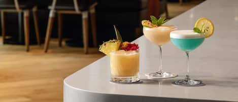 Zona de bar con taburetes y barra.