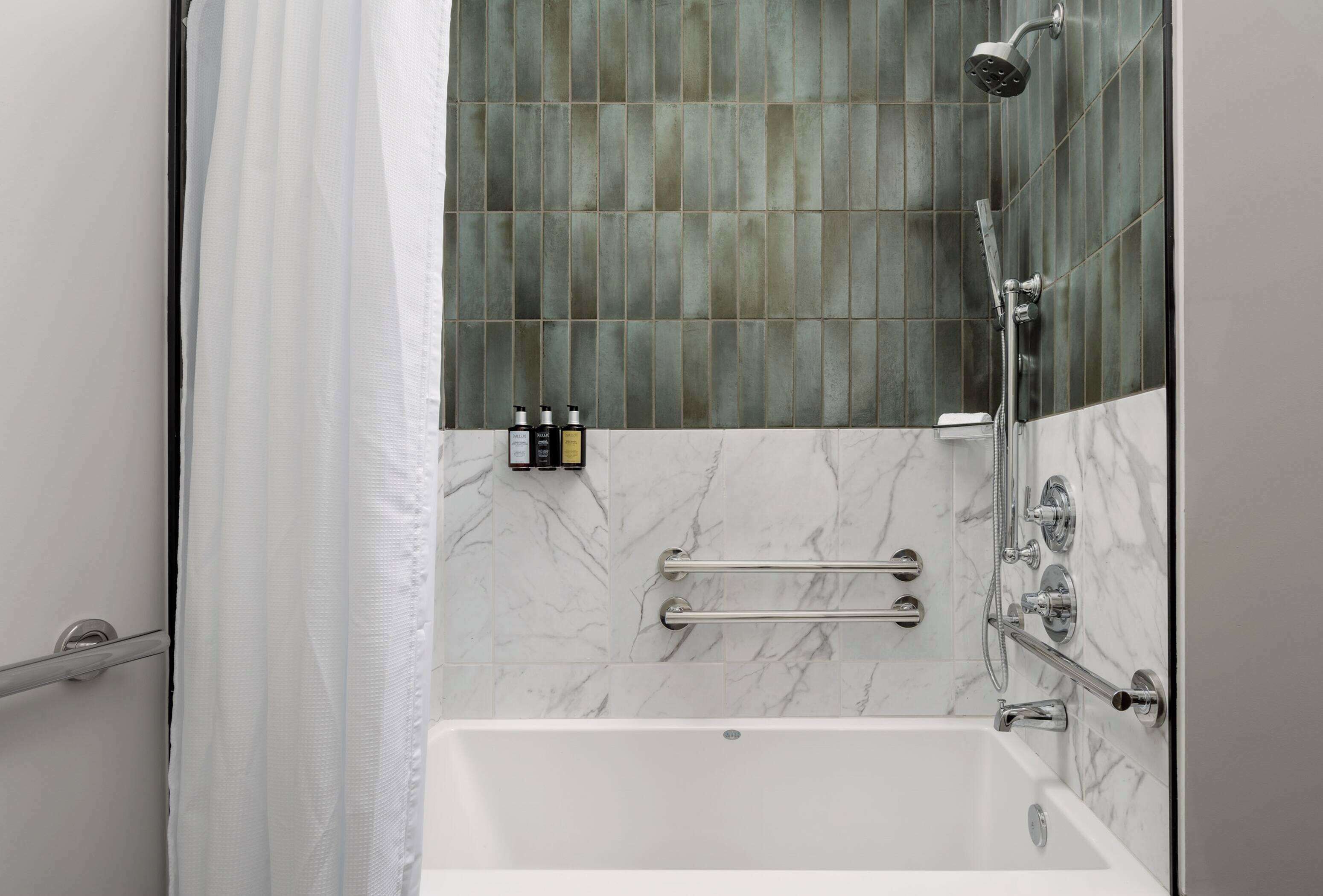 Une salle de bain moderne équipée d’une baignoire, d’une douche et d’une paroi de douche en verre.