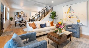 A modern living room with a sofa, two armchairs, a coffee table, and a staircase. - Spacious, Immaculate 4350 sq ft Home• Amazing Kitchen (Coeur d'Alene)