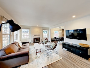 Relax in this stylish living room with a comfortable sofa, armchairs, and a fireplace.