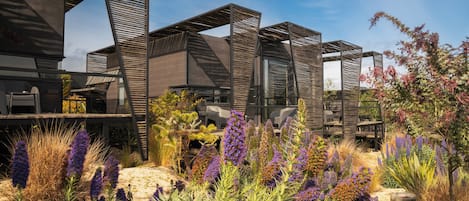 Uma estrutura arquitetônica moderna com formas geométricas e um jardim com diversas plantas.