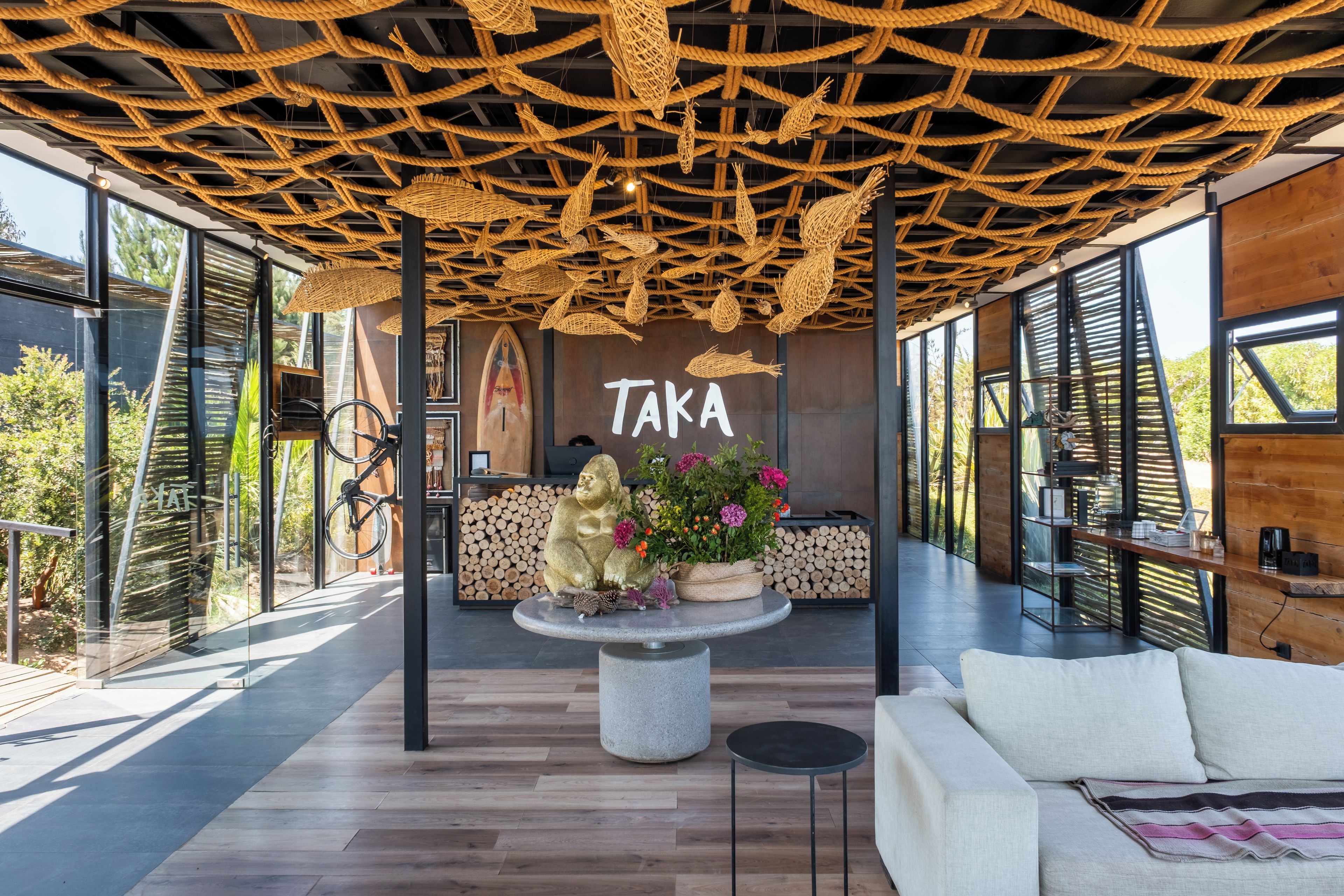 A modern interior with a wooden ceiling, a reception desk, and a sofa.