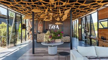 A modern interior with a wooden ceiling, a reception desk, and a sofa.