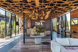 A modern interior with a wooden ceiling, a reception desk, and a sofa.