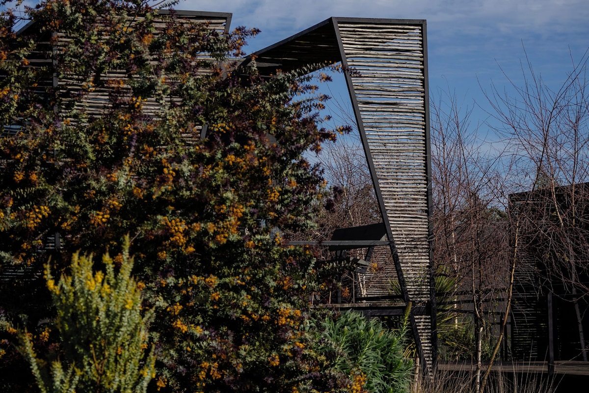 A building with a slanted roof and a wooden structure in front.
