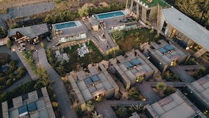 An aerial view of a modern resort with multiple buildings, a swimming pool, and outdoor seating areas. - Taka Matanzas (Navidad)
