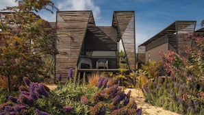 A modern building with a sloped roof and wooden paneling. - Taka Matanzas (Navidad)