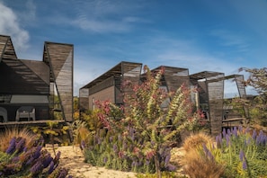 A modern architectural structure with multiple levels and a garden area with various plants. - Taka Matanzas (Navidad)