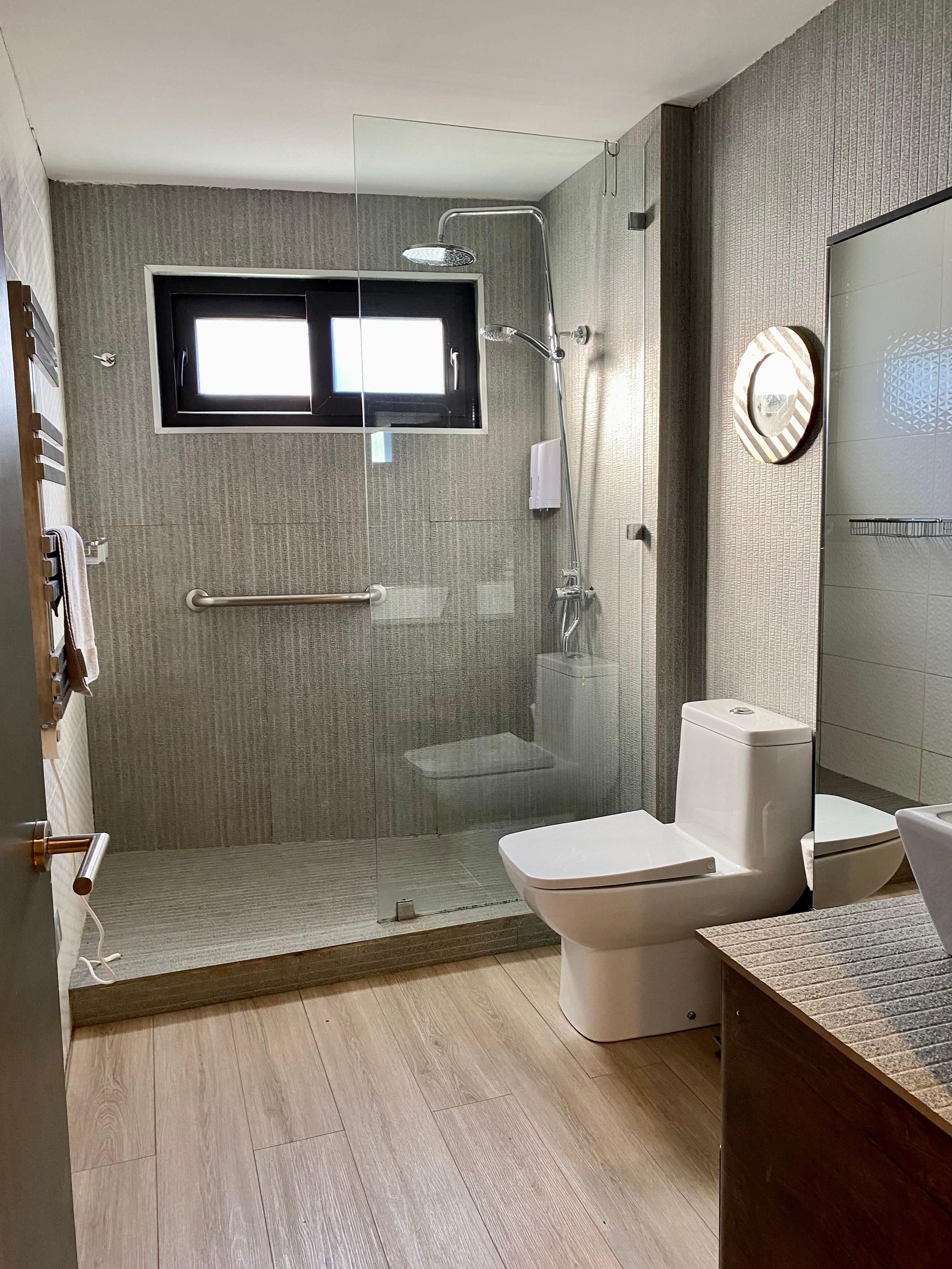 Une salle de bain moderne avec une douche à parois de verre, des toilettes et un lavabo.