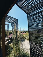 Una estructura arquitectónica moderna con diseño geométrico, que ofrece una vista despejada del paisaje y la vegetación circundantes.