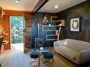 Una sala de estar moderna con un sofá, una mesa de centro de vidrio y una chimenea.