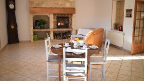 Un comedor con chimenea, un reloj y un espejo en la pared.