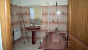 Un baño con lavamanos pedestal, bañera y ducha.