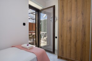 A bedroom with a bed, a sliding glass door leading to a balcony, and a wooden wardrobe. - Anastasia & Marie luxury & traditional residence with large jacuzzi 1 minute sea (Κίσσαμος)