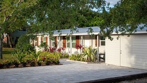A single-story house with a front porch, a garage, and a small garden area with various plants. - Modern Farmhouse Retreat – Heated Pool & Close to Beaches! (Stuart)