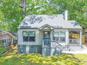 A small, single-story house with a front porch and a chimney.