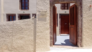 Ein Durchgang zu einem Gebäude, dessen Schild „Diva Santorini Luxury Villa“ zeigt.