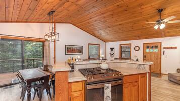 A spacious kitchen with wooden cabinets, a large island, and a built-in oven.