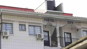 A building with a tiled facade, air conditioning units, and a sign that reads "FUSSEL CITY". - 1 Bed Studio Sleeps 2 - Canal Views, Balcony, Wifi (Douala)