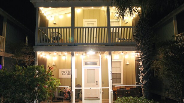 A two-story building with a balcony, a sign reading "Welcome to Pools and Paradise," and a door labeled "B31."